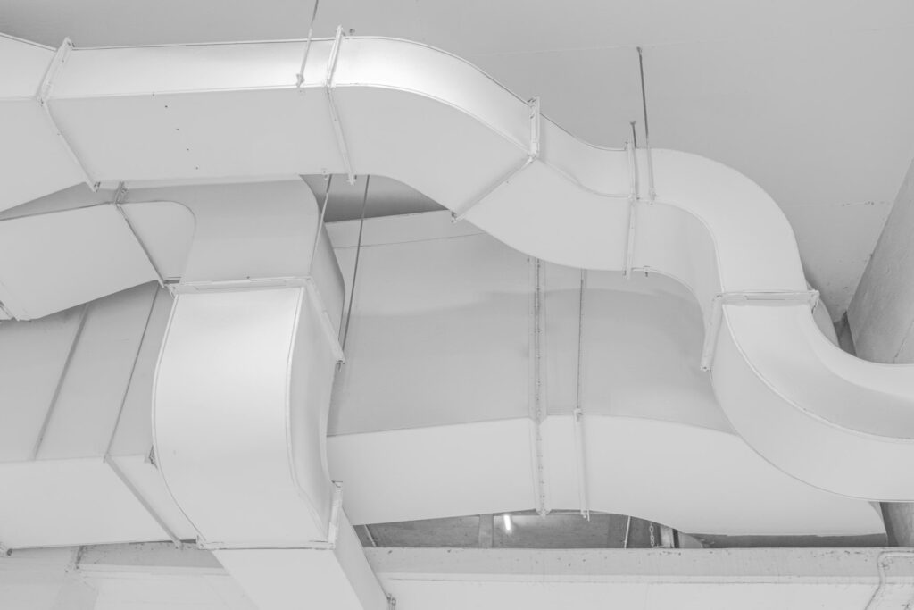 White ventilation ducts suspended below a ceiling