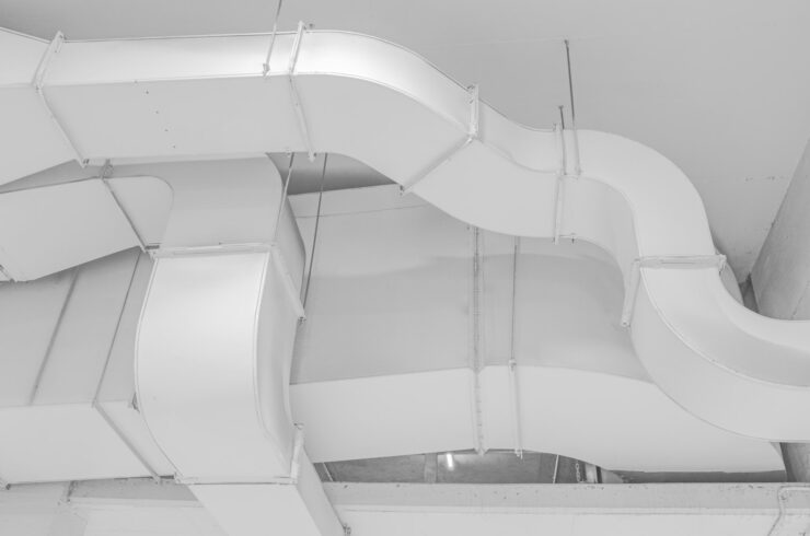 White ventilation ducts suspended below a ceiling