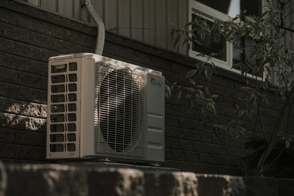 Outdoor air conditioning unit against a brick wall