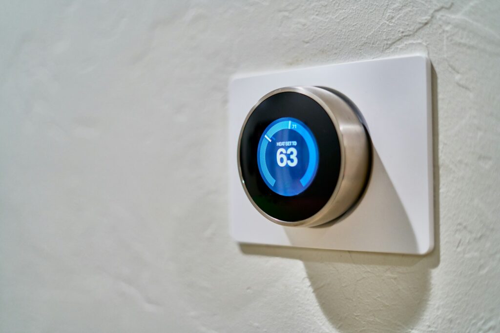 Wall mounted thermostat displaying 63 degrees