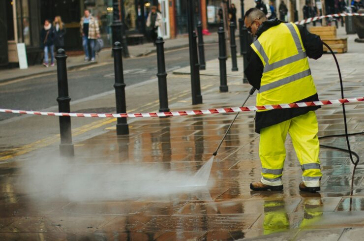 Worker pressure washing a surface