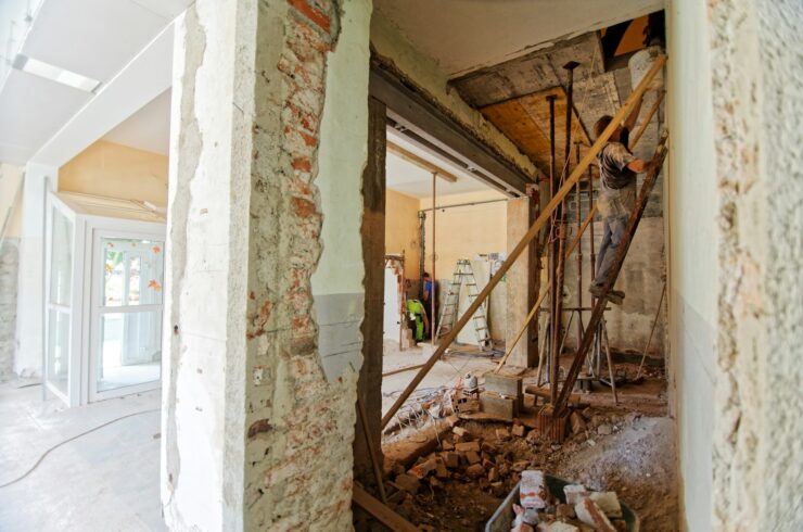 Worker on a ladder inside a room under renovation