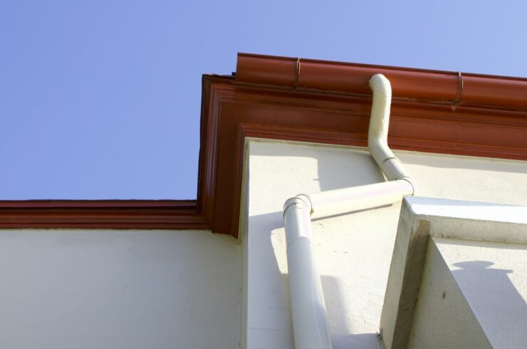 Gutter and downspout on a cream-colored building